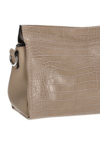 Bolso beige con textura grabada de cocodrilo, detalles en cuero liso y herrajes plateados. Presenta una forma redondeada y un bolsillo lateral.