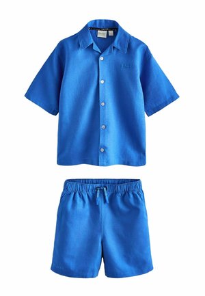 Blå kortærmet skjorte med knapper og krave samt matchende shorts med elastik i taljen og snøre, begge med diskret "BAKER" branding.