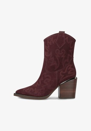 Botas western de ante burdeos con puntera afilada y detallados bordados intrincados. Presentan un tacón grueso con textura de madera.