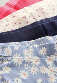 Patru perechi de pantaloni scurți din bumbac elastic expuse: roz, crem cu imprimeu floral, albastru închis și albastru deschis cu margarete albe. Fiecare are o talie moale.