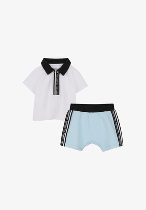 Tweedelig kinderoutfit bestaande uit een wit poloshirt met een zwarte kraag en ritssluiting, gecombineerd met lichtblauwe korte broek met zwarte accenten.