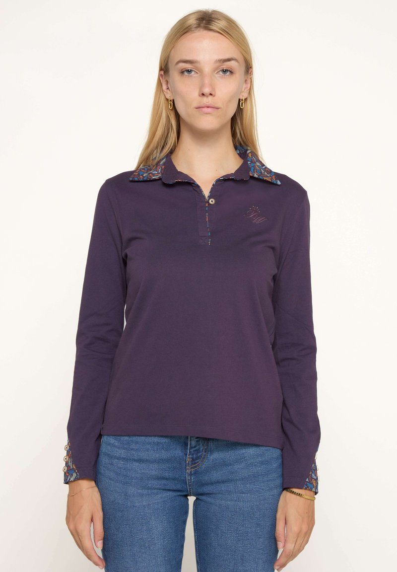 Polo à manches longues de couleur violette avec un col et des poignets à motifs, doté d'une patte de boutonnage et d'un logo brodé sur la poitrine.