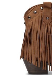 Botín de ante marrón con flecos, tachuelas metálicas y un tacón de madera, que presenta un borde superior curvado y una textura suave.
