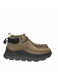 Stivali impermeabili alla caviglia marroni con suola in gomma texturizzata, tomaia in pelle, punta tonda e colletto in tessuto nero. Presenta una chiusura con lacci e una linguetta per il sollevamento.