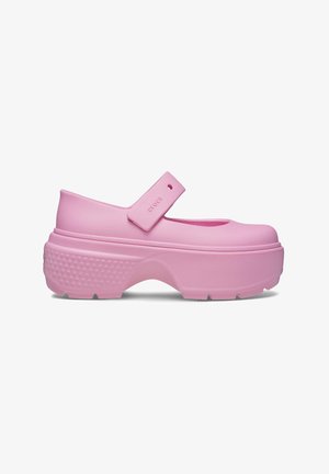 Pink clogs with a rounded toe, strap across the instep, and textured sole. Made of flexible material with a thick, chunky platform.