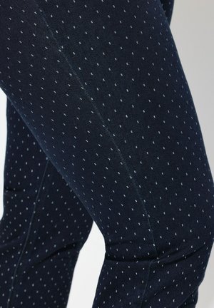 Navy blue relaxed fit leggings made of stretchy fabric with a subtle dotted pattern. Features flat seams and a smooth texture.