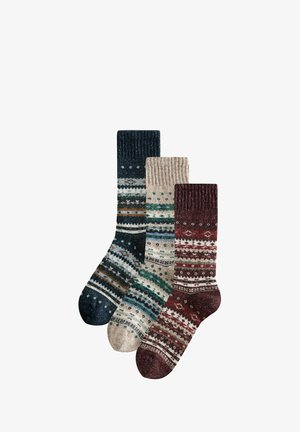Drei gestrickte Socken mit Mustern in Marineblau, Beige und Burgunderrot mit gestreiften und gepunkteten Fair-Isle-Designs, übereinander auf einem weißen Hintergrund angeordnet.
