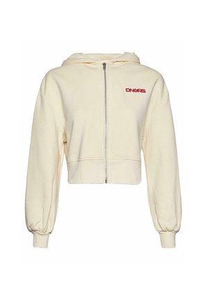 Lyhyemmät hupparit, valmistettu kermabeigeä kangasta, jossa on etuvetoketju, suuret pallomaiset hihat ja punainen brodeerattu logo rinnassa.