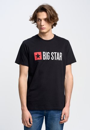 Zwarte katoenen T-shirt met witte tekst "BIG STAR" en een rode vierkant met een zwarte ster. Korte mouwen en ronde hals. Casual pasvorm.