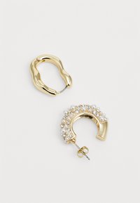 Gold-tone hoop earrings featuring a smooth, twisted design and another adorned with pearls and rhinestones. Both have a secure clasp.