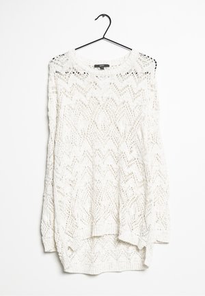 Suéter blanco de manga larga tejido con un patrón de zigzag colgado en una percha negra contra un fondo blanco.