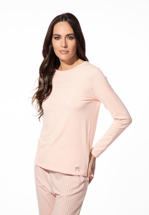Lichtroze lange mouwen top met een ronde halslijn, zachte stof en een klein logo detail; gecombineerd met gemusterde roze pyjamabroek.