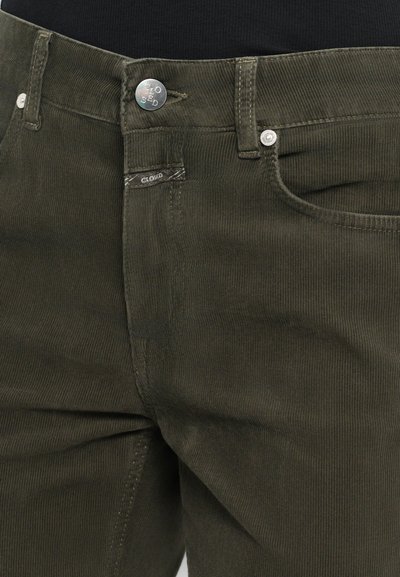Dark green corduroy pants with a ribbed texture, silver button closure, and front pockets. Features stitched detailing and brand label.