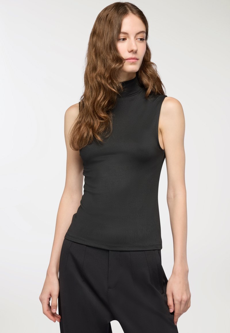 Top senza maniche nero a collo alto realizzato in un tessuto liscio e elasticizzato, caratterizzato da un design aderente e un collo alto.
