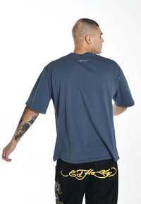 Short-sleeve navy blue t-shirt with a relaxed fit, made of soft fabric, featuring a small embroidered logo at the back neckline.