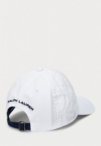 Gorra de béisbol de algodón blanca con visera curvada, que presenta "RALPH LAUREN" bordado en azul marino en la parte posterior. Correa ajustable con herrajes de metal.