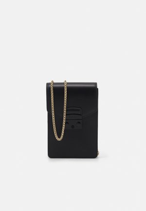 Petit sac bandoulière en cuir noir avec une chaîne dorée et un rabat avant avec fermeture à verrou.