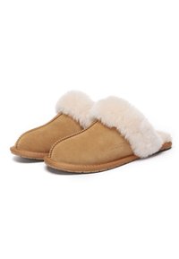 Tan suede slippers with a fluffy cream-colored fur cuff. Rounded toe shape and stitched detailing along the edges. Flat rubber sole.