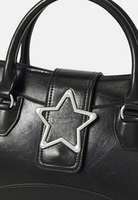 Black synthetic handbag featuring a smooth texture, rounded handles, and a silver star-shaped accent on the front flap.