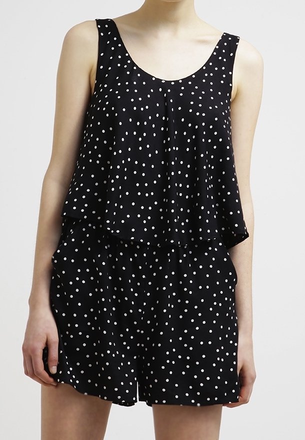 Combinaison noire à pois avec un design superposé, présentant un haut sans manches, une coupe décontractée et une taille élastique.