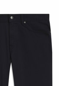 Granatowe spodnie o gładkiej fakturze, wyposażone w przednią kieszeń i metalowe guziki. Tkanina wygląda na trwałą i ma casualowy charakter.