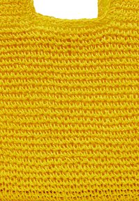 Gul vævet tote bag med en tekstureret overflade, der har et netdesign og en åben top. Fremstillet af fleksibelt, holdbart plastmateriale.