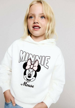 Hoodie blanc avec un grand motif de Minnie Mouse bordé de noir, portant un nœud rose, avec le texte "MINNIE Mouse" en dessous, texture douce.