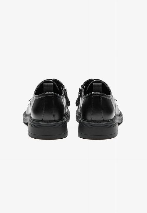Chaussures en cuir noir avec une finition lisse, bout rond et semelle en caoutchouc basse. Présentent une languette à l'arrière et des détails de couture minimalistes.