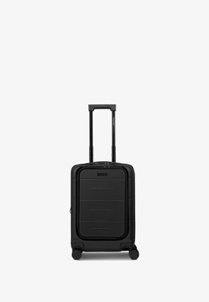 Valigia rigida nera con superficie liscia, chiusura con cerniera, ruote spinner incassate e manico estensibile per un facile trasporto.