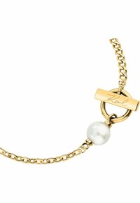 Gouden schakelarmband met een ronde witte parel en een toggle-sluiting met gegraveerd "Karl" detail. Gladde textuur, hedendaags ontwerp.