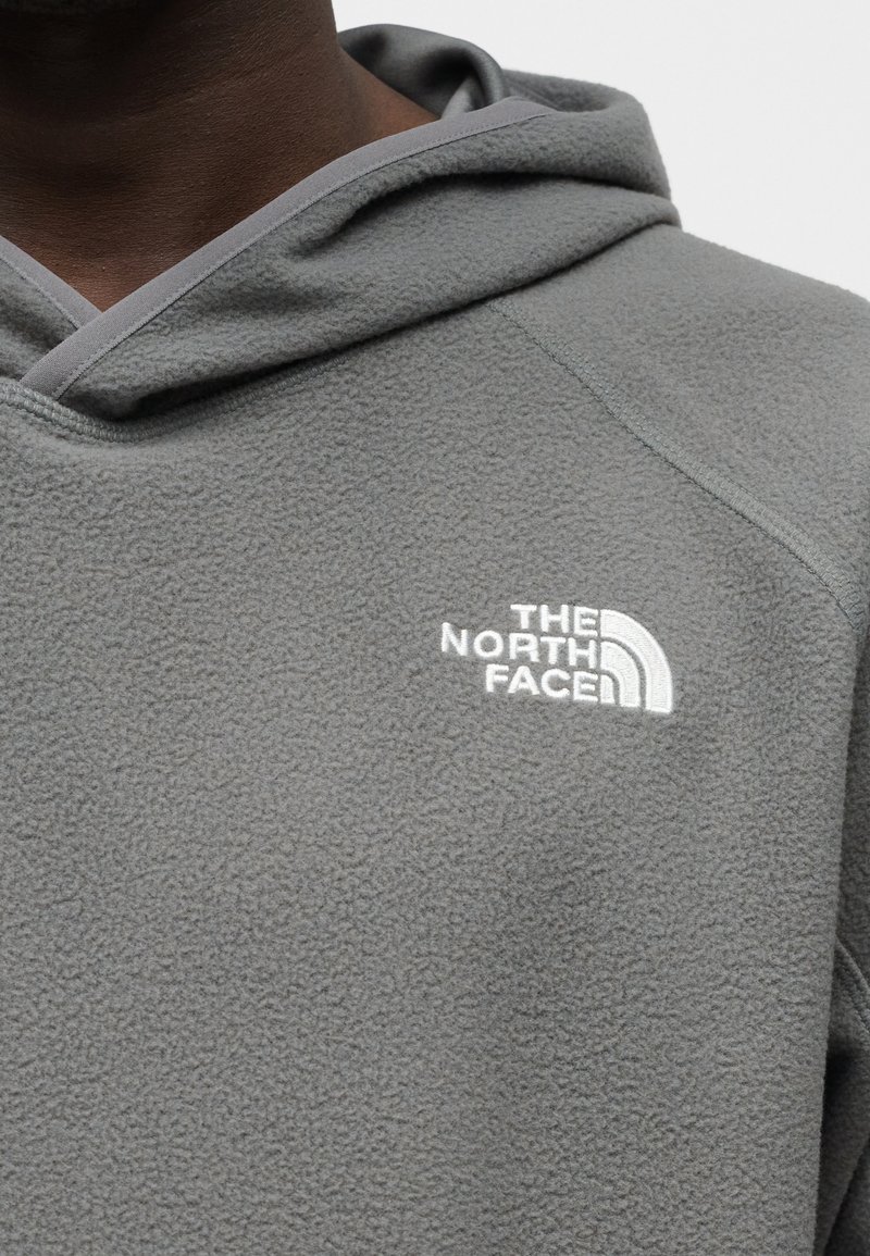 Gray fleece hoodie featuring a white logo on the chest, with a textured surface and contrasting light gray trim along the hood.