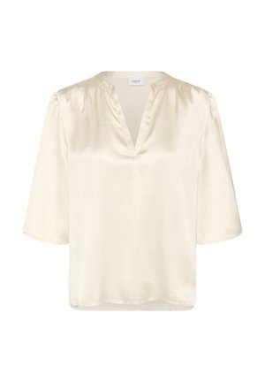 Trumpas rankovėmis bliusonas iš švelnaus, grietinėlės spalvos satino, su giliu V formos iškirpimu ir švelniomis raukšlėmis ant pečių. Lygus paviršius, laisvas siluetas.