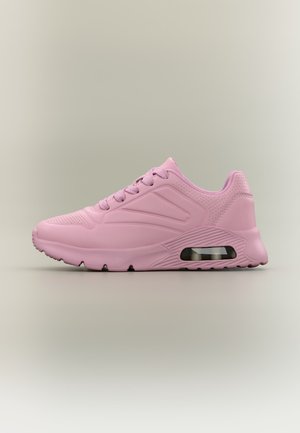 Light pink athletic sneaker with textured sole, air cushion in heel, lace-up design, and perforated details on a neutral background.