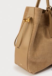 Καστανή τσάντα χειρός με υφή κροκοδείλου, λείες δερμάτινες λεπτομέρειες και χρυσά μεταλλικά στοιχεία στο πλάι.