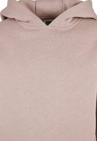 Felpa con cappuccio rosa chiaro realizzata in tessuto misto cotone, dotata di tasca a marsupio e cappuccio con cordino. Design minimalista con texture morbida.