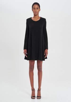 Schwarzes Shiftkleid mit langen Ärmeln, rundem Ausschnitt und fließender Silhouette; aus einem glatten Stoff gefertigt, knielanger Schnitt, minimalistisches Design.
