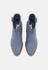 Botas de tobillo de ante azul con una textura suave, punta afilada y recortes decorativos. Presenta cremalleras dobles en los lados para facilitar su uso.