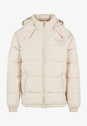 Doudoune beige clair avec fermeture éclair, design matelassé, capuche ajustable et poignets élastiques ; présente une broderie de logo sur la poitrine.