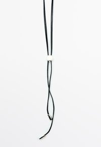 Bolo tie en cuir noir avec un accent central en argent circulaire et des embouts métalliques aux extrémités des cordons. Design épuré et minimaliste.