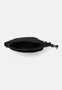 Pochette nera in tessuto con superficie texturizzata, chiusura con zip e una sottile tracolla per il trasporto; l'interno è non foderato e spazioso.