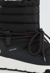 Botte noire imperméable avec un dessus en nylon rembourré, semelle en caoutchouc noir texturé et lacets tressés sombres pour un maintien sécurisé.