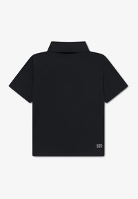 Μαύρο πόλο με κοντά μανίκια, κλασικό γιακά και υφασμάτινη υφή. Διαθέτει μία μικρή ετικέτα "ULTRA DRY" στο κάτω αριστερό μέρος.