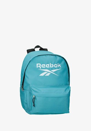 Mochila turquesa de Reebok con gran logo blanco, bolsillo frontal con cremallera y correas de hombro acolchadas negras.