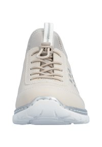 Chaussure de sport beige avec une texture lisse, des lacets et un accent argenté métallique sur la semelle. Comprend une languette blanche et des trous d'aération.