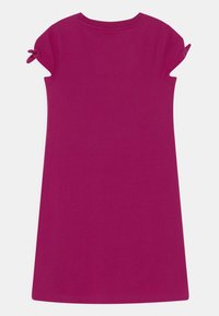 Bawełniana sukienka w kolorze fuksji o krótkich rękawach z ozdobami w postaci węzłów. Prosty fason w kształcie litery A i gładka tekstura. Brak widocznych wzorów.