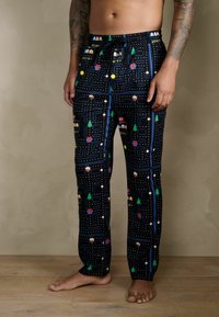 Fekete pizsamanadrág színes Pac-Man játék mintával, karakterekkel, fákkal és pöttyökkel díszítve. Puha, rugalmas anyagból készült.