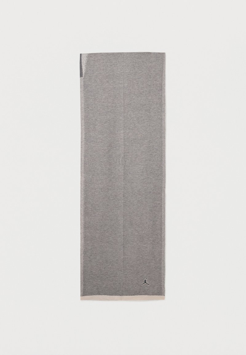 Διπλωμένο γκρι κασκόλ με λεπτές οριζόντιες ρίγες και μικρό μαύρο λογότυπο κοντά στο κάτω άκρο σε απλό λευκό φόντο.