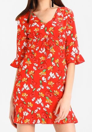 Rotes Blumenkleid mit V-Ausschnitt, rüschenshort Ärmel und einer Bindeschleife an der Taille. Das Muster umfasst weiße und gelbe Blumen.
