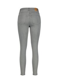 Gray skinny jeans made of denim, featuring a mid-rise waist, two back pockets, and a leather patch at the waistband. Smooth texture.