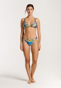 Bikini komplekts su daugiaspalviu mėlynos, geltonos ir oranžinės spalvų raštu. Trikampio formos viršus su reguliuojamomis petnešėlėmis ir suderinamos bikini kelnaitės.